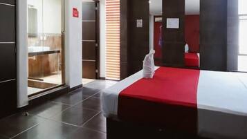 Una habitación de hotel con una cama, un armario y una puerta que da a un baño.