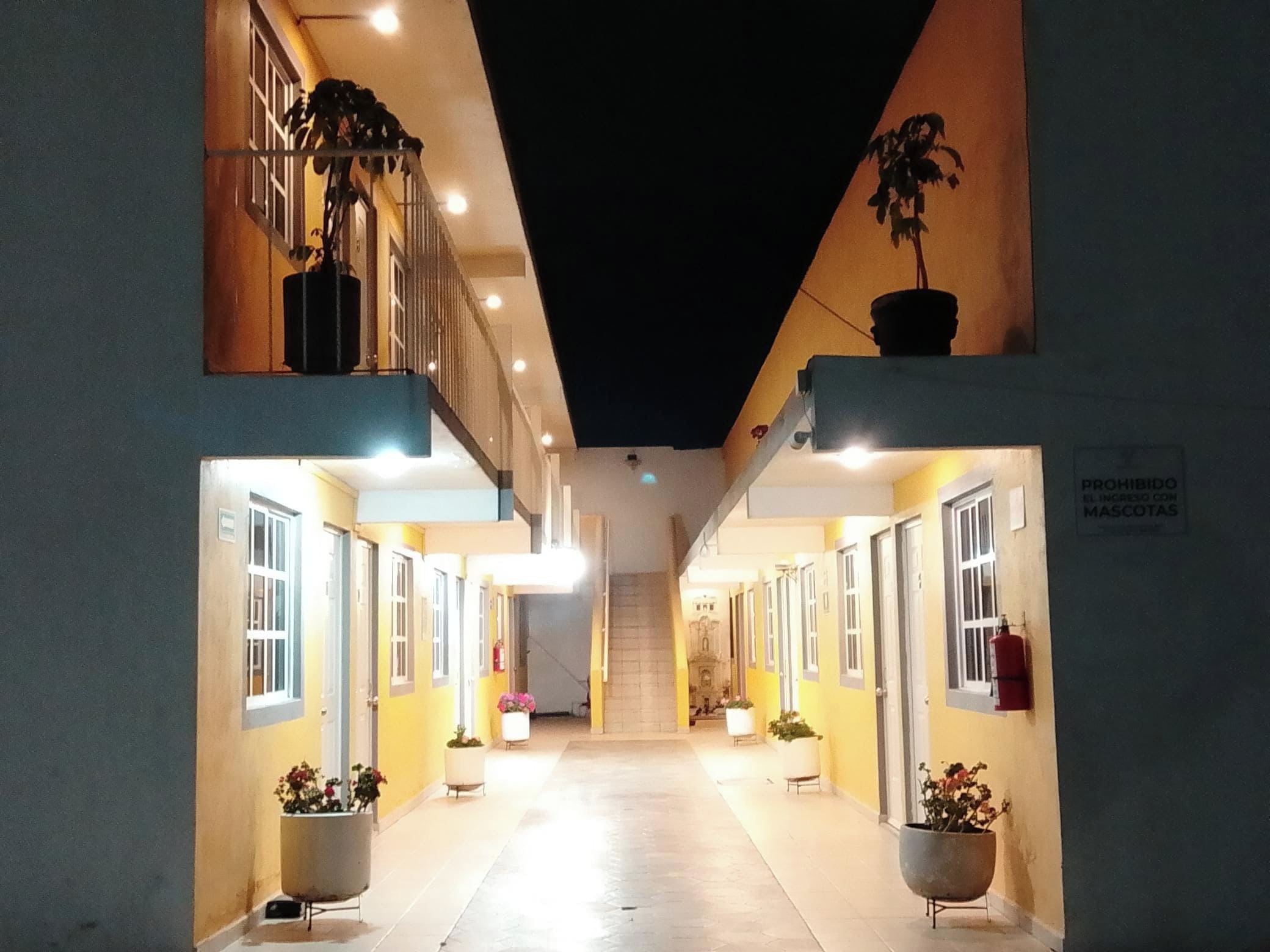 A corridor with doors on both sides, leading to a staircase.