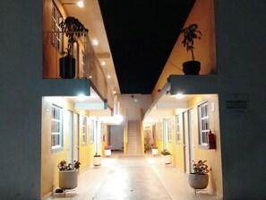 A corridor with doors on both sides, leading to a staircase. - Posada del Ángel (Mineral de la Reforma)