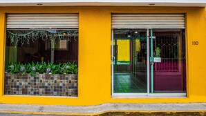 Un hotel llamado Posada del Ángel, con fachada amarilla y un letrero sobre la entrada.