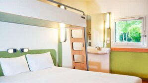 Une chambre à coucher avec un lit, une table de chevet, une fenêtre et un miroir.