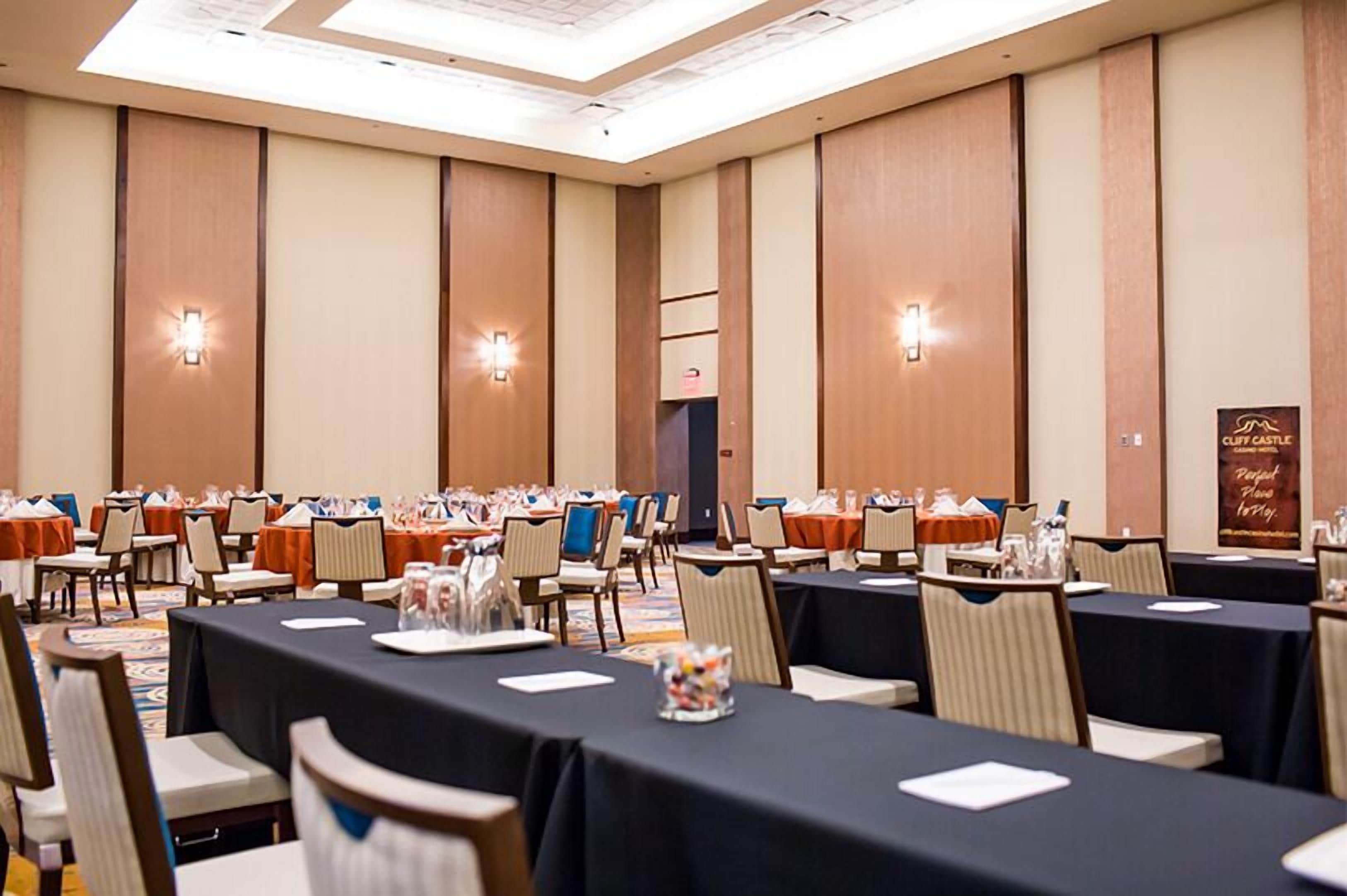A conference room with multiple tables and chairs, equipped with nameplates and water bottles.