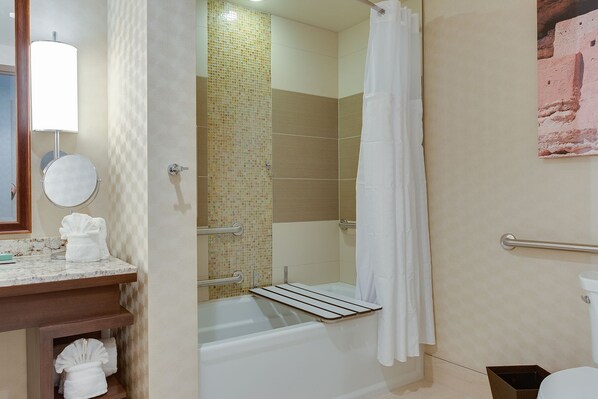 Un baño con ducha, bañera, inodoro, lavabo con espejo y toallero.