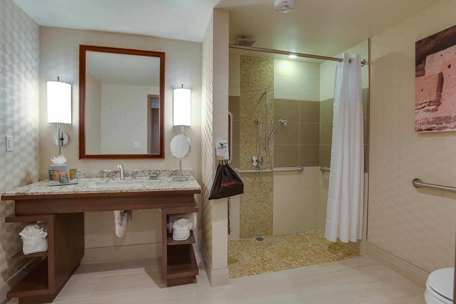 A bathroom with a marble sink, two mirrors, a towel rack, and a shower area with a glass door.