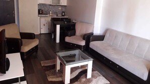 A compact living space with a sofa, armchairs, a coffee table, and a kitchenette. - Tuyap Apartments (Istanbul)