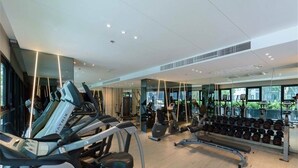 A modern gym with treadmills, weight machines, and a bench. - The base pattaya condo (Pattaya)