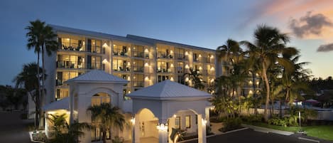 Ein mehrstöckiges Hotel mit Balkonen und einem gut beleuchteten Eingang.