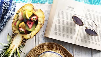 A book open to Chapter 8 titled "Life is a journey" next to a fruit bowl and a straw hat.