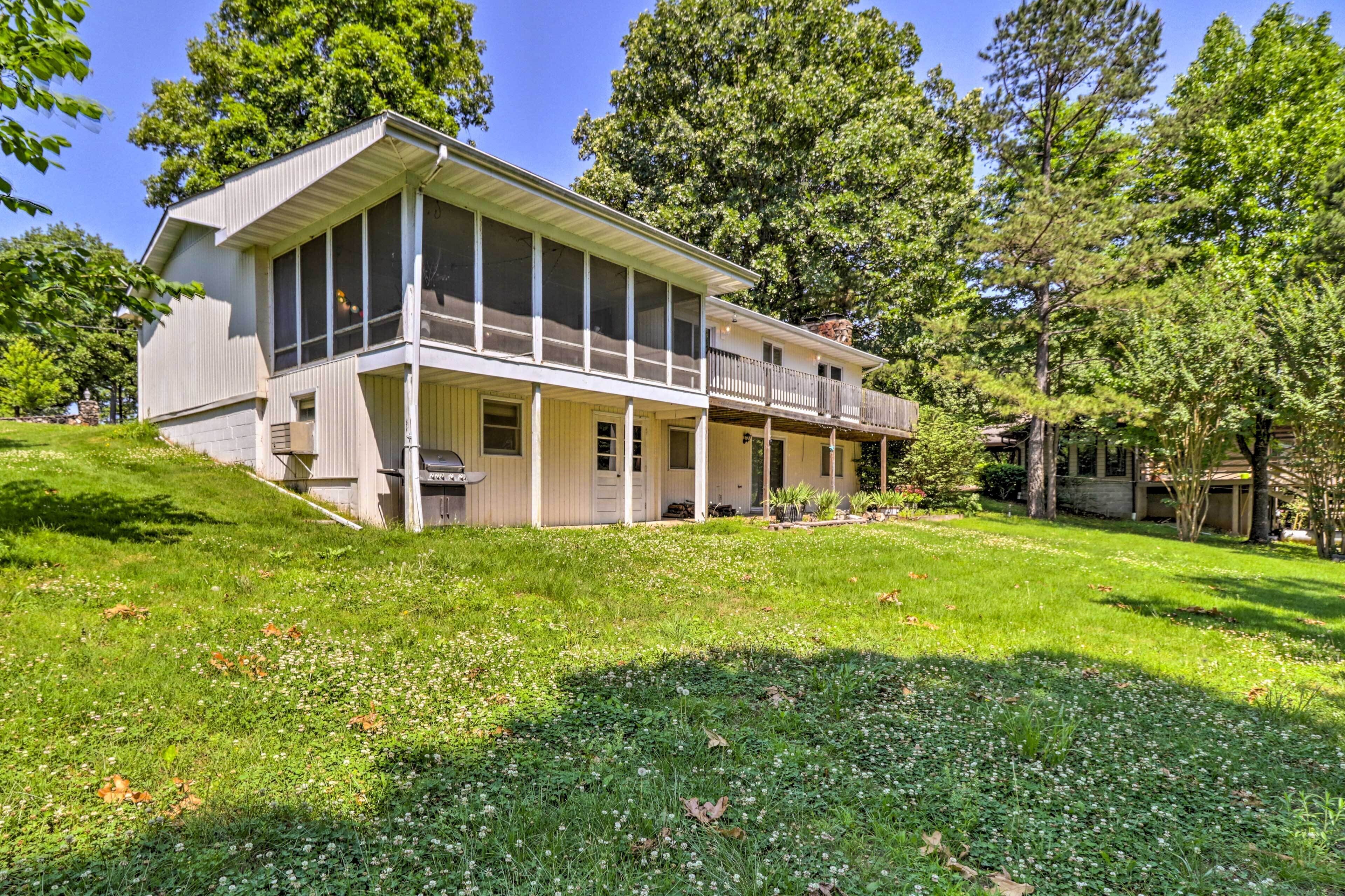 A two-story house with a large front porch, a screened porch on the upper floor, and a well-maintained lawn.