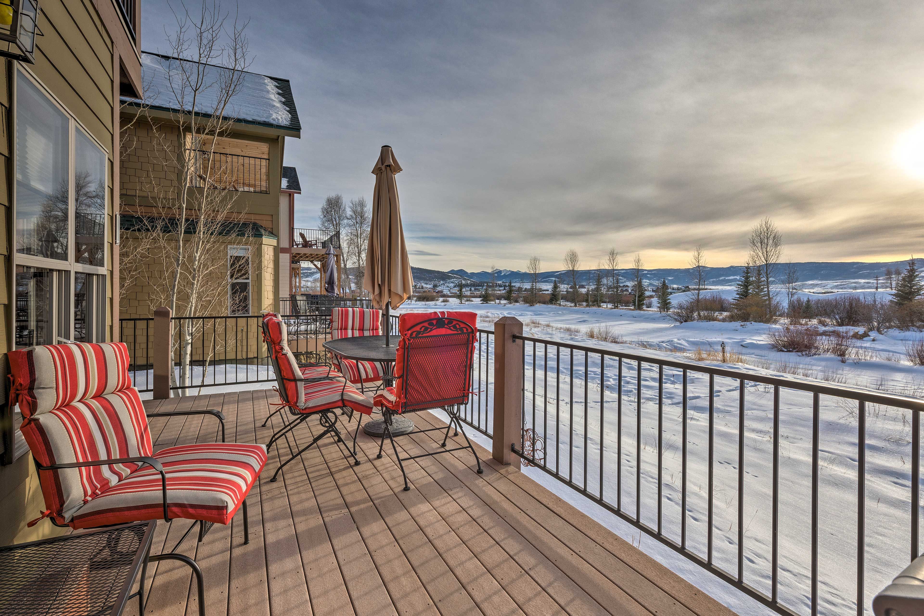 A deck with outdoor furniture and a view of a snowy landscape.