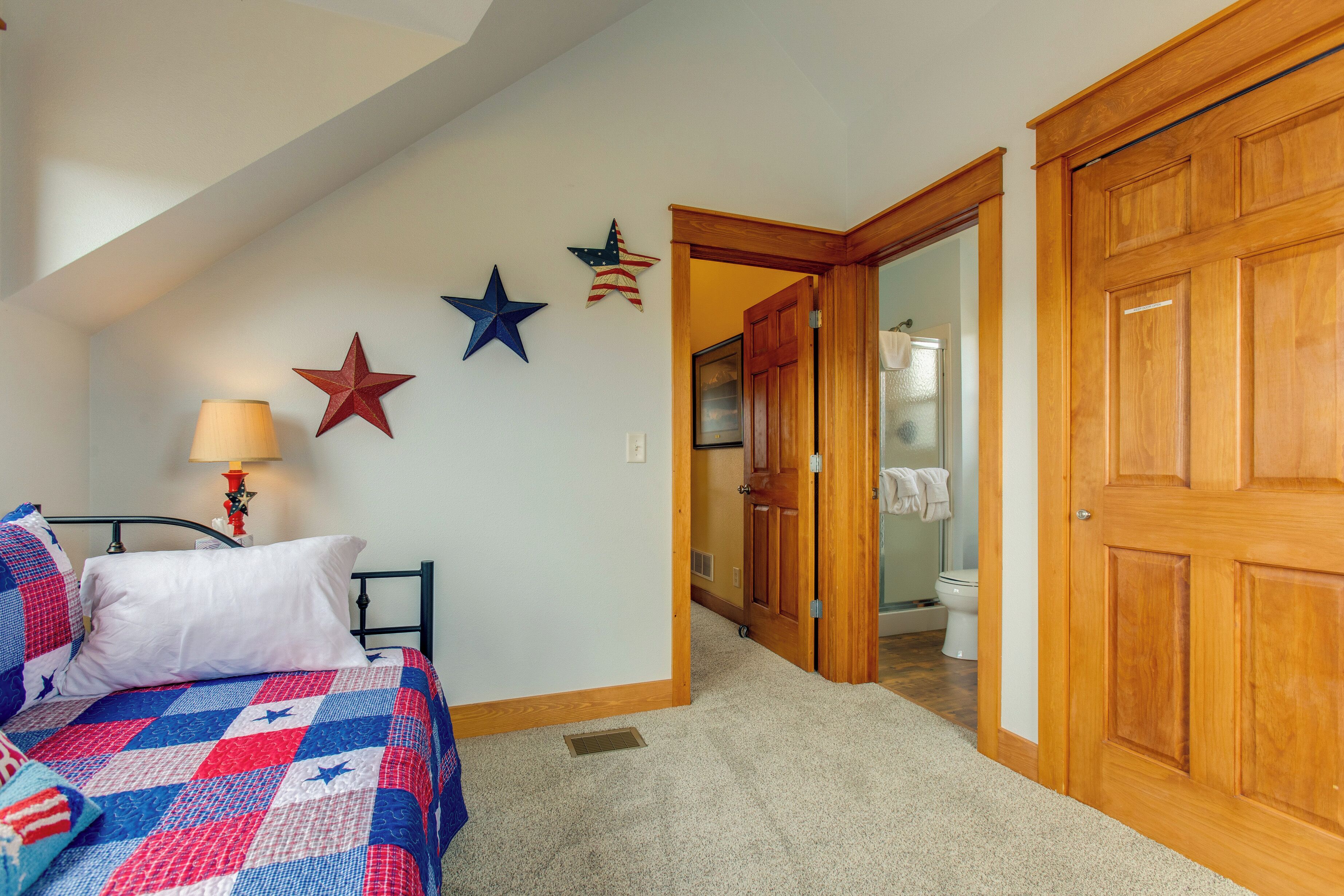 A bedroom with a bed, a nightstand, and a wall with star decorations.
