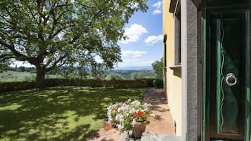 Surrounded by a lush lawn and a majestic tree, this serene retreat offers a peaceful escape amidst rolling hills.