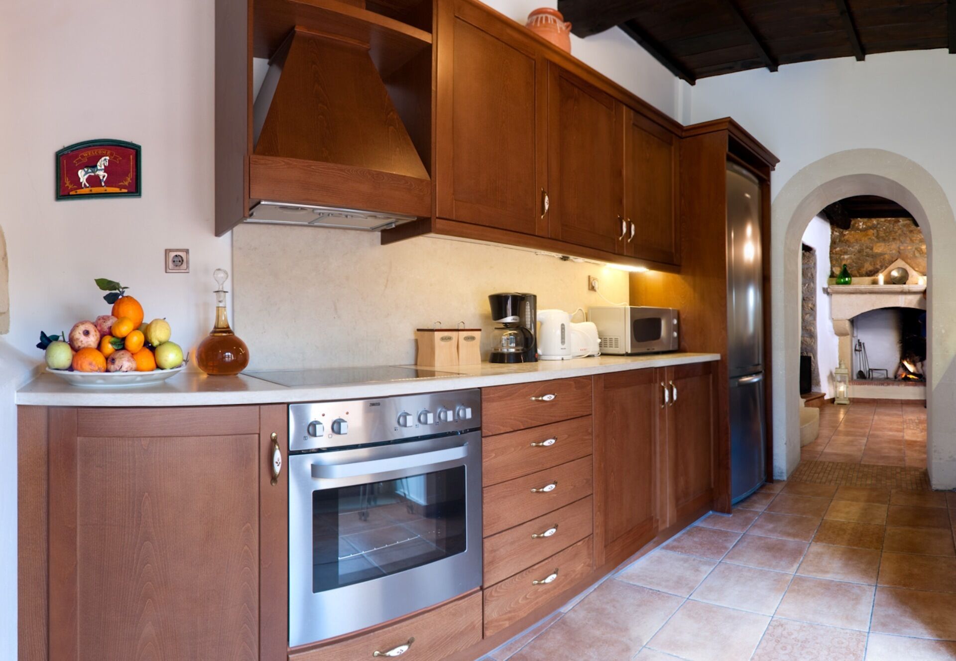 A kitchen with wooden cabinets, a stainless steel oven, and a refrigerator.