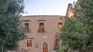A building with a stone pathway leading to a wooden door. - Private villa with private pool and amazing view in an unspoilt environment (Rethymno)