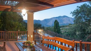 A wooden deck with a bench and table, overlooking a mountainous landscape. - Private villa with private pool and amazing view in an unspoilt environment (Rethymno)