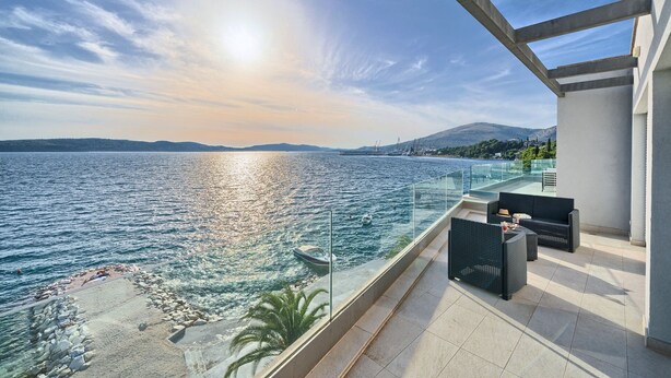 A balcony with a view of the sea, a glass railing, and outdoor furniture. - Beachfront Villa Deep Blue with Pool I (Trogir)
