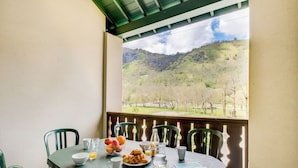 A table set for breakfast with a view of a hilly landscape. - Les Jardins de Balnea Loudenvielle 4PD10 (Loudenvielle)
