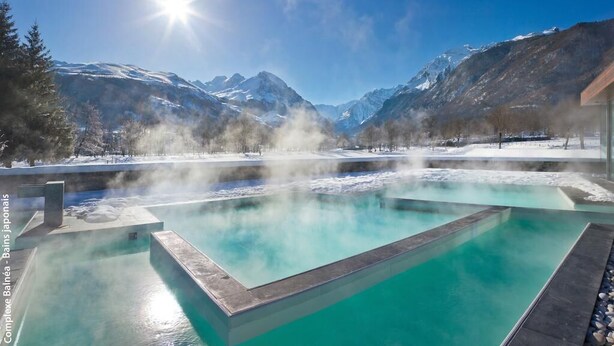 A clear, blue pool with steam rising from the water, surrounded by snow-covered mountains and a clear sky. - Les Jardins de Balnea Loudenvielle 4PD10 (Loudenvielle)