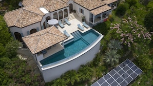 Una casa grande y moderna con piscina, varias habitaciones y jardín.