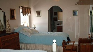 A bedroom with two beds, a dresser, a chair, and a mirror.