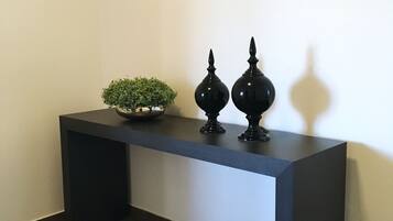 A dark-colored console table with a small potted plant and two black decorative vases.