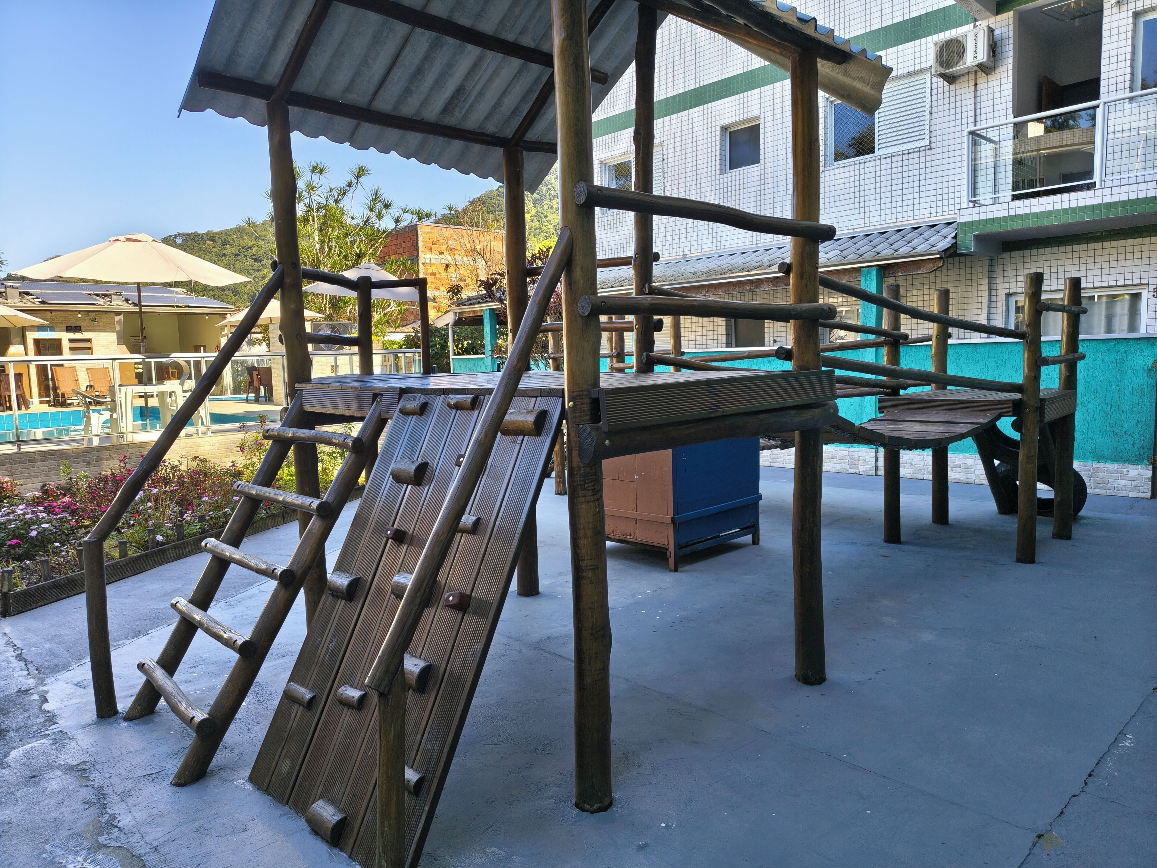 A playground structure with a climbing wall and a slide.