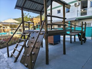 A playground structure with a climbing wall and a slide.
