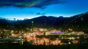 A town at night with illuminated buildings and a mountain in the background. - Moonstruck Apartment 1 (Gatlinburg)