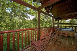 A wooden deck with a railing, a table, and chairs. - Natural Attractions Apartment 3 (Gatlinburg)