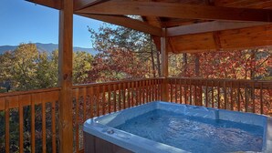 A hot tub on a wooden deck with a view of autumn trees and mountains. - Moonshiners View Apartment 2 (Gatlinburg)