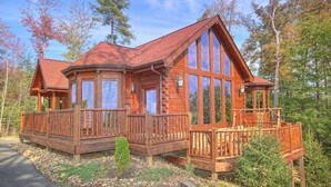 A wooden cabin with large windows, a balcony, and a porch. - Tranquility Apartment 2 (Sevierville)