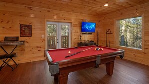 A wooden room with a pool table, a television, and a piano. - Tranquility Apartment 2 (Sevierville)