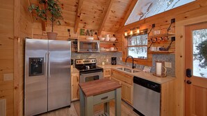 A compact kitchen with a refrigerator, microwave, stove, sink, and dishwasher. - Foolin Around Apartment 1 (Sevierville)