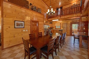 A wooden cabin interior with a dining area, kitchen, and a balcony. - Sweet Tranquility Pool Lodge Apartment 4 (Cosby)