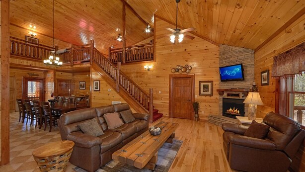A spacious wooden cabin interior with a living room, dining area, and a fireplace. - Sweet Tranquility Pool Lodge Apartment 4 (Cosby)