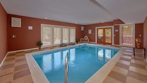 An indoor swimming pool with a checkered floor, sliding glass doors, and a small play area with a ball goal. - Sweet Tranquility Pool Lodge Apartment 4 (Cosby)