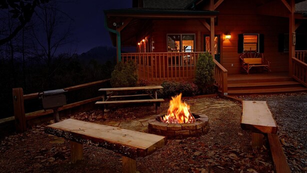 A wooden cabin with a porch, a fire pit, and two picnic tables. - Time Stands Still Apartment 3 (Sevierville)
