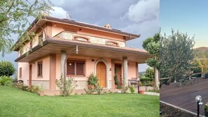 Una casa de dos pisos con balcón y jardín.