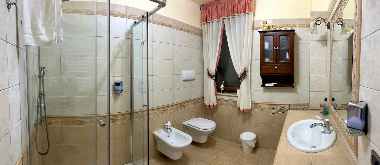A bathroom with a glass-enclosed shower, a bidet, a toilet, and a sink.