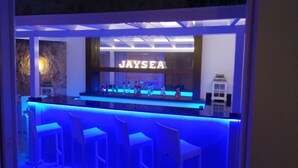 Un coin bar avec une enseigne indiquant « JAYSEA » et plusieurs bouteilles disposées sur le comptoir.