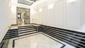 A grand hallway with marble steps and a glass ceiling.