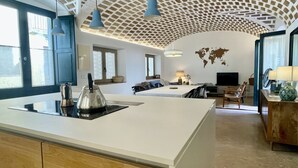 A modern hotel room with a large kitchen area, a dining table, and a TV. - CASA ROSA DEL PORT (L'Escala)