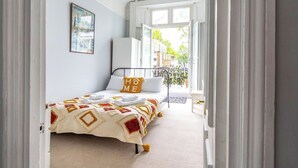 Een slaapkamer met een bed, een raam en uitzicht op het omliggende landschap.