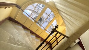 Gradi d'espiral amb vista d'un carrer a través d'una finestra a dalt.