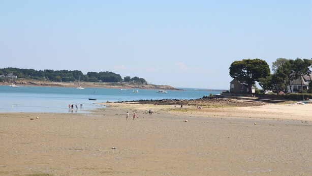 A beach with a sandy shore, a few people, and boats in the water. There are trees and a building on the right. - Little parenthesis in Trinité-Sur-Mer (La Trinité-sur-Mer)