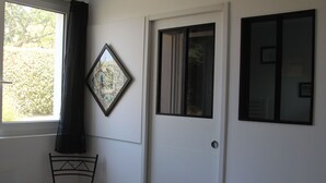 A room with a white door, a framed picture on the wall, and a chair near a window. - Little parenthesis in Trinité-Sur-Mer (La Trinité-sur-Mer)