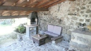 Eine Gartenmauer aus Stein mit einer Steinsitzbank und einem kleinen Tisch.