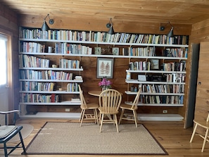 Relax in a quiet space with a bookshelf, two chairs, and a small table.