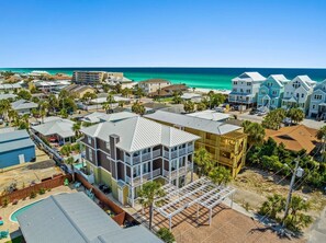 A coastal residential area with houses, a pool, and a beach view.