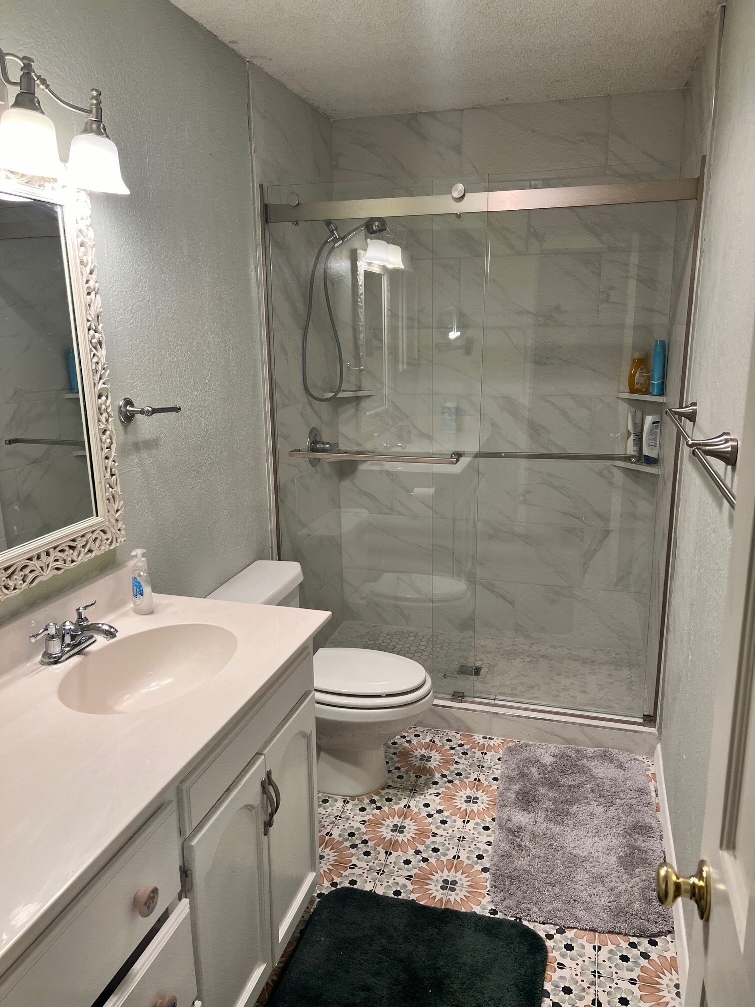 Une salle de bain avec un lavabo, des toilettes et une douche.